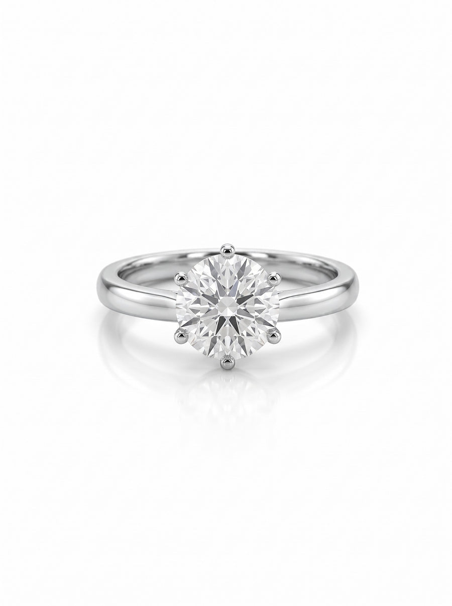 Round brilliant cut diamond solitaire engagement ring in a six-claw platinum setting on a white background.
