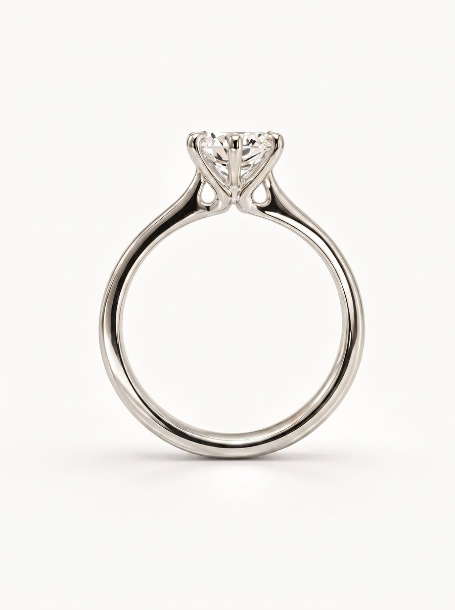 Round cut solitaire diamond engagement ring in polished white gold with a talon prong setting.