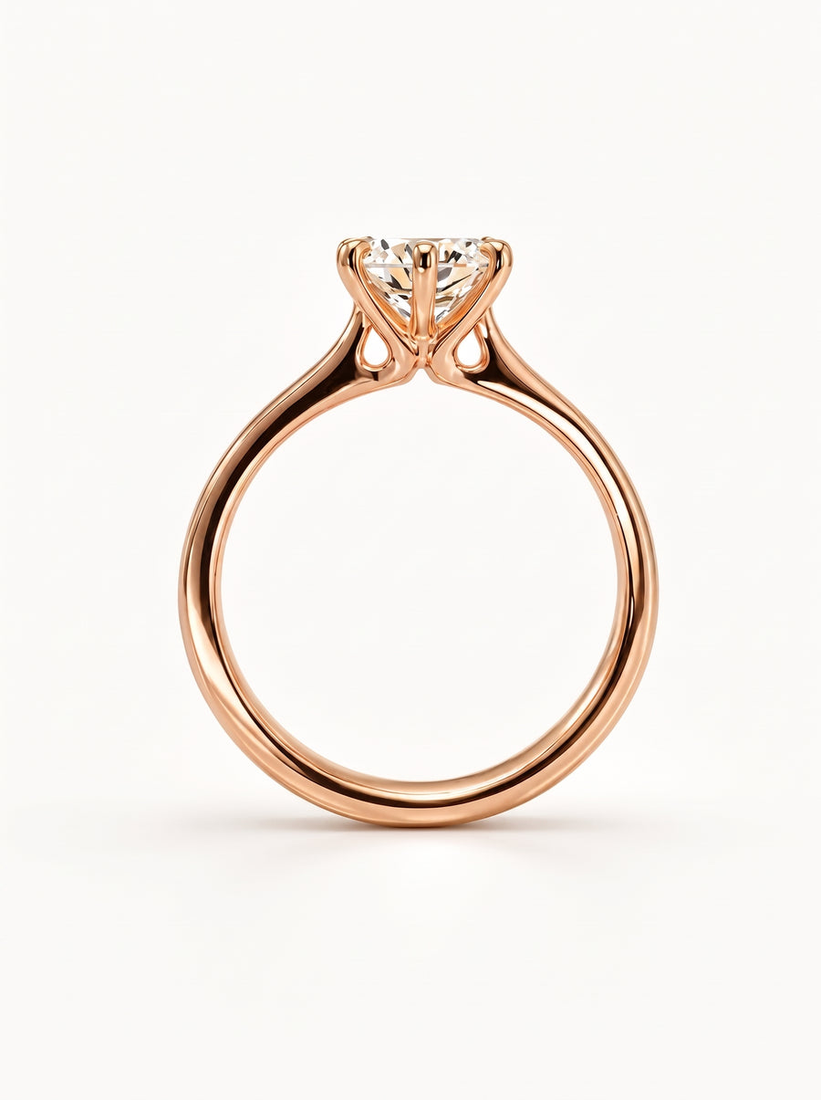 Rose gold solitaire engagement ring featuring a round cut diamond in a six-prong talon setting.