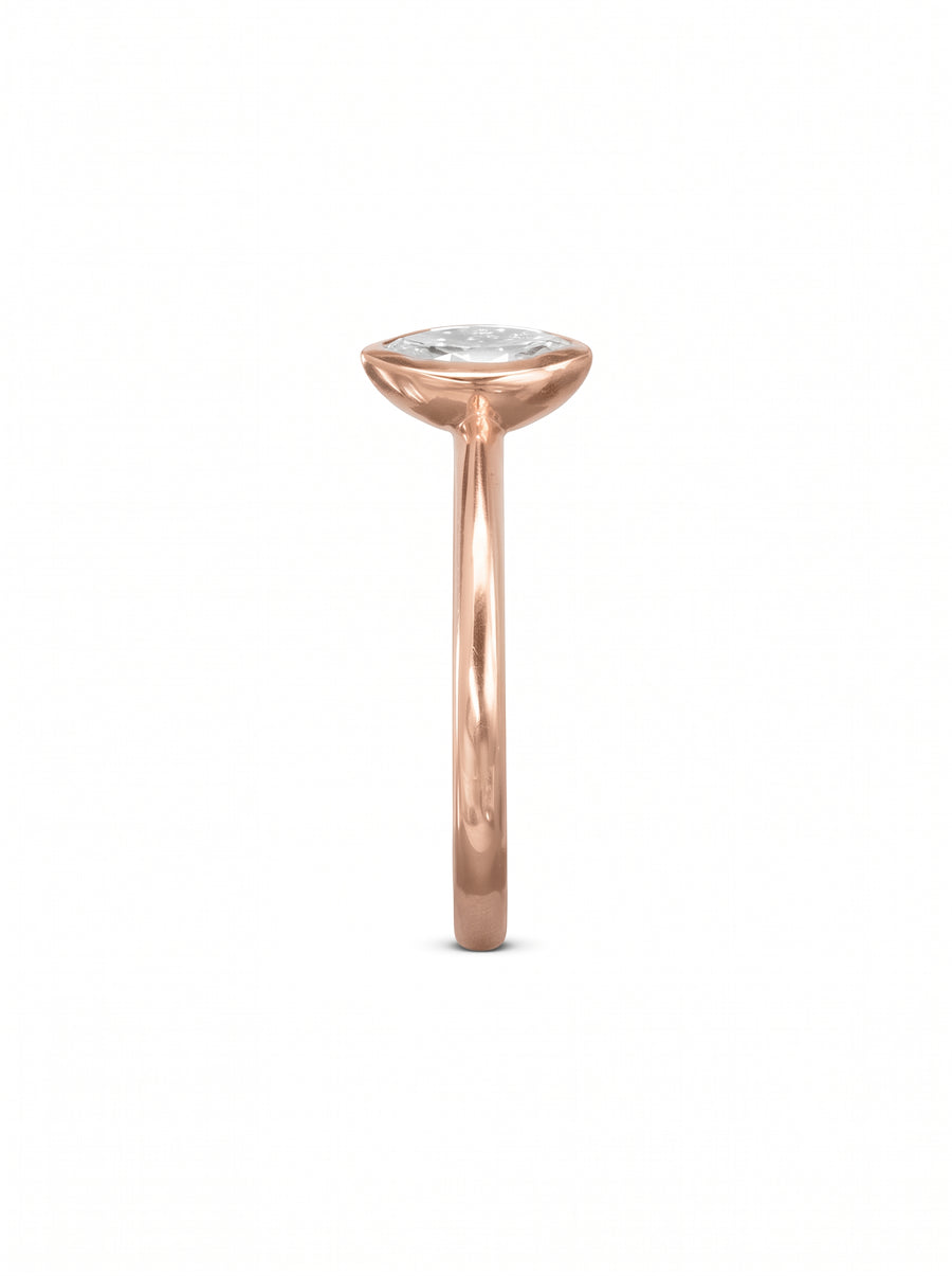 Rose gold engagement ring featuring a marquise cut diamond in a smooth bezel setting.