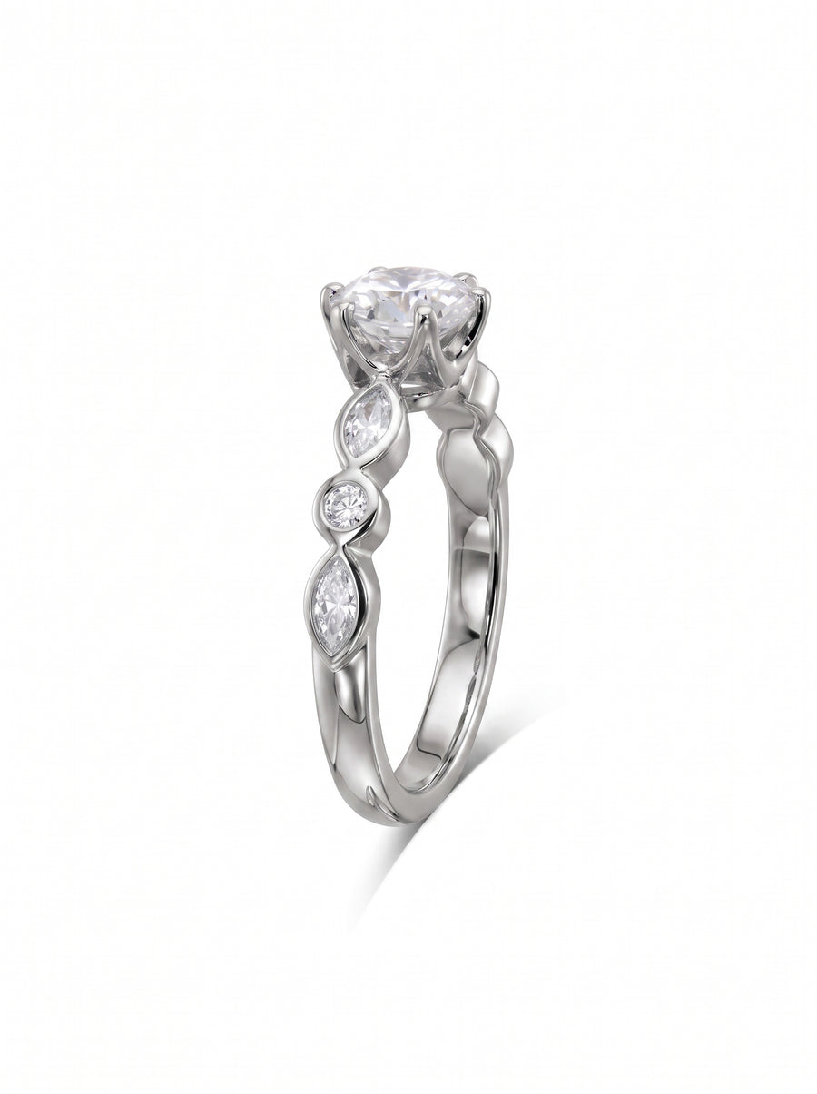 Round cut diamond engagement ring in white gold with marquise and round accent stones on a crown setting.