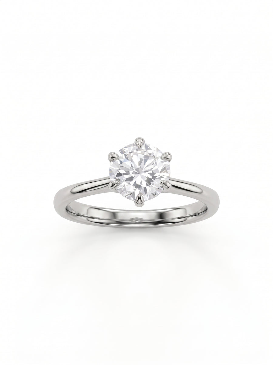 Round cut diamond solitaire engagement ring in polished silver-tone metal with a six-prong setting.