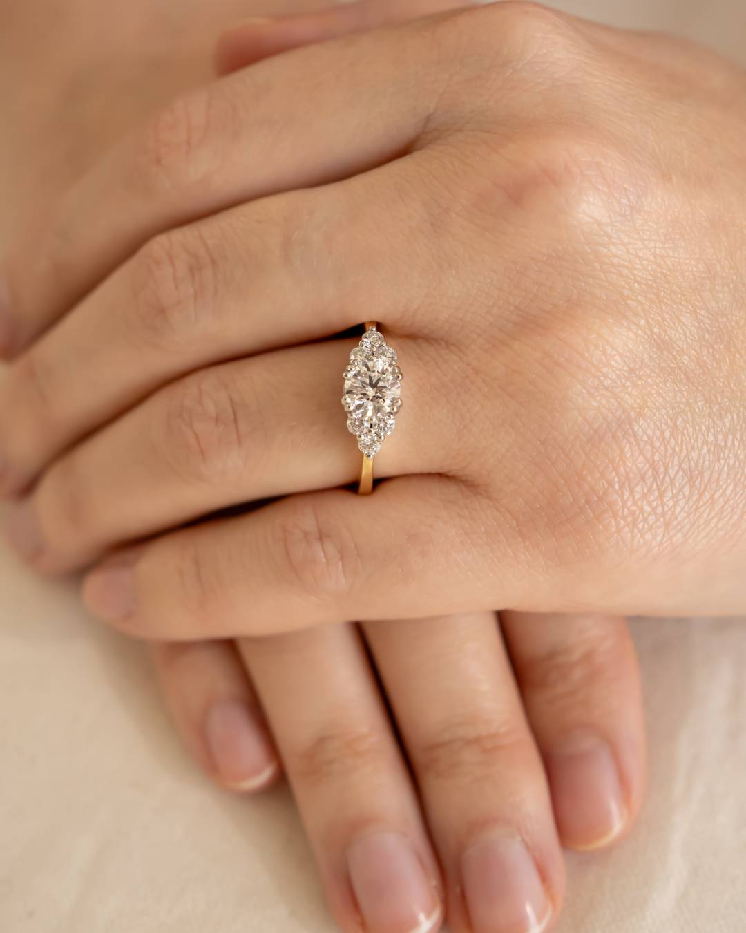 Hand wearing gold ring with marquise cluster diamond setting, elegant fine jewellery