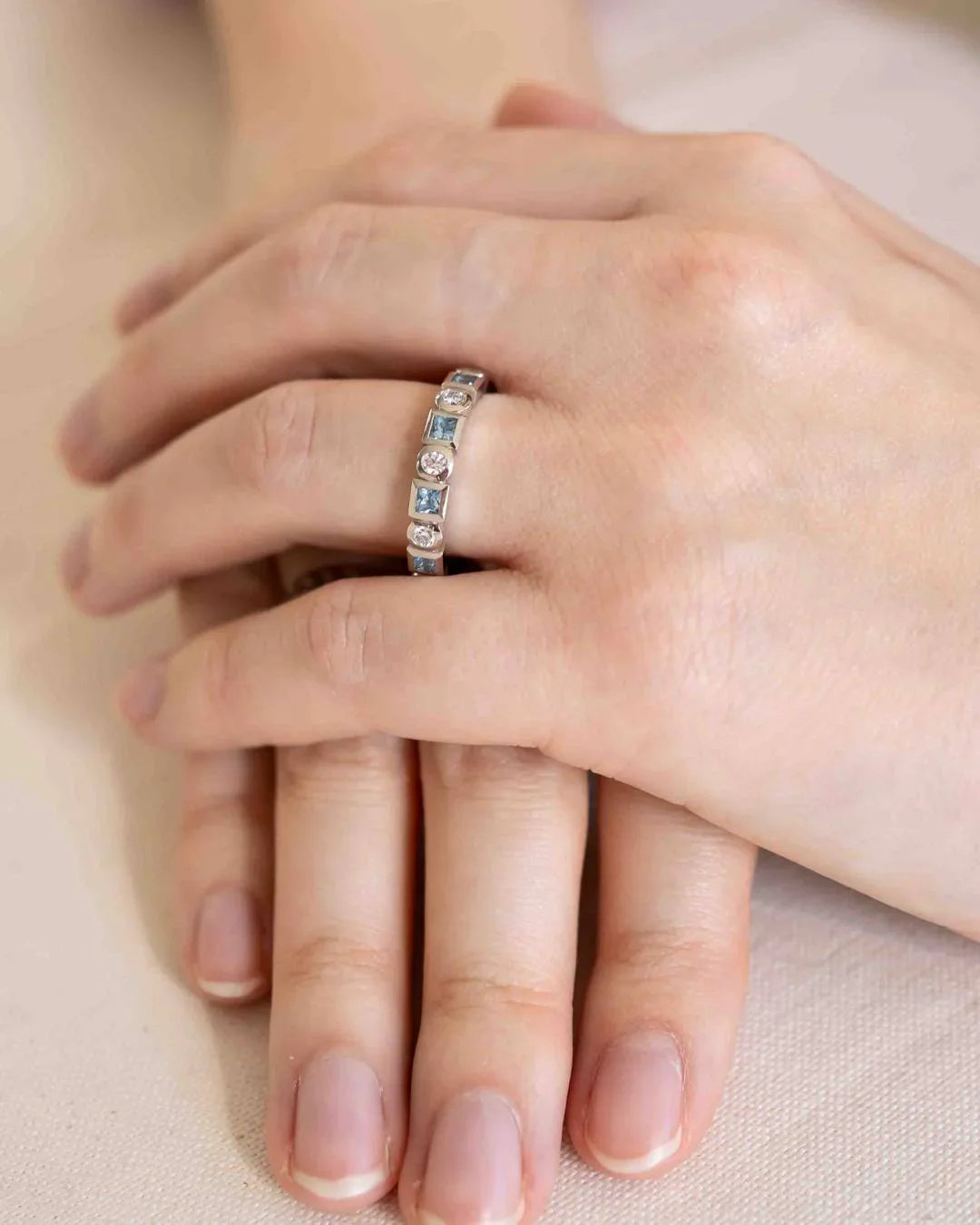 Hand-worn silver gemstone eternity ring, elegant and handmade, on a natural background