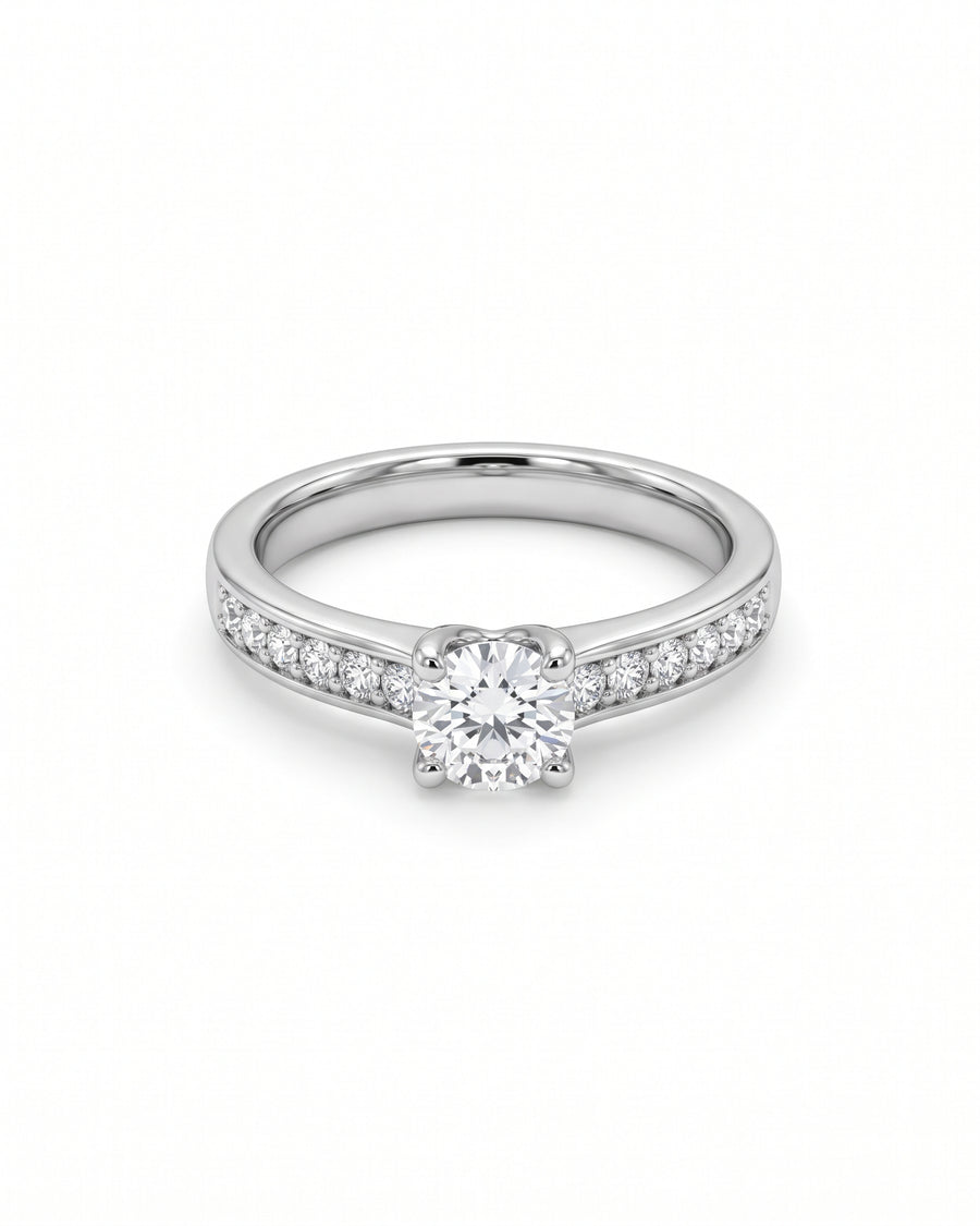 Platinum engagement ring with a round brilliant diamond center stone and pavé diamond shoulders.