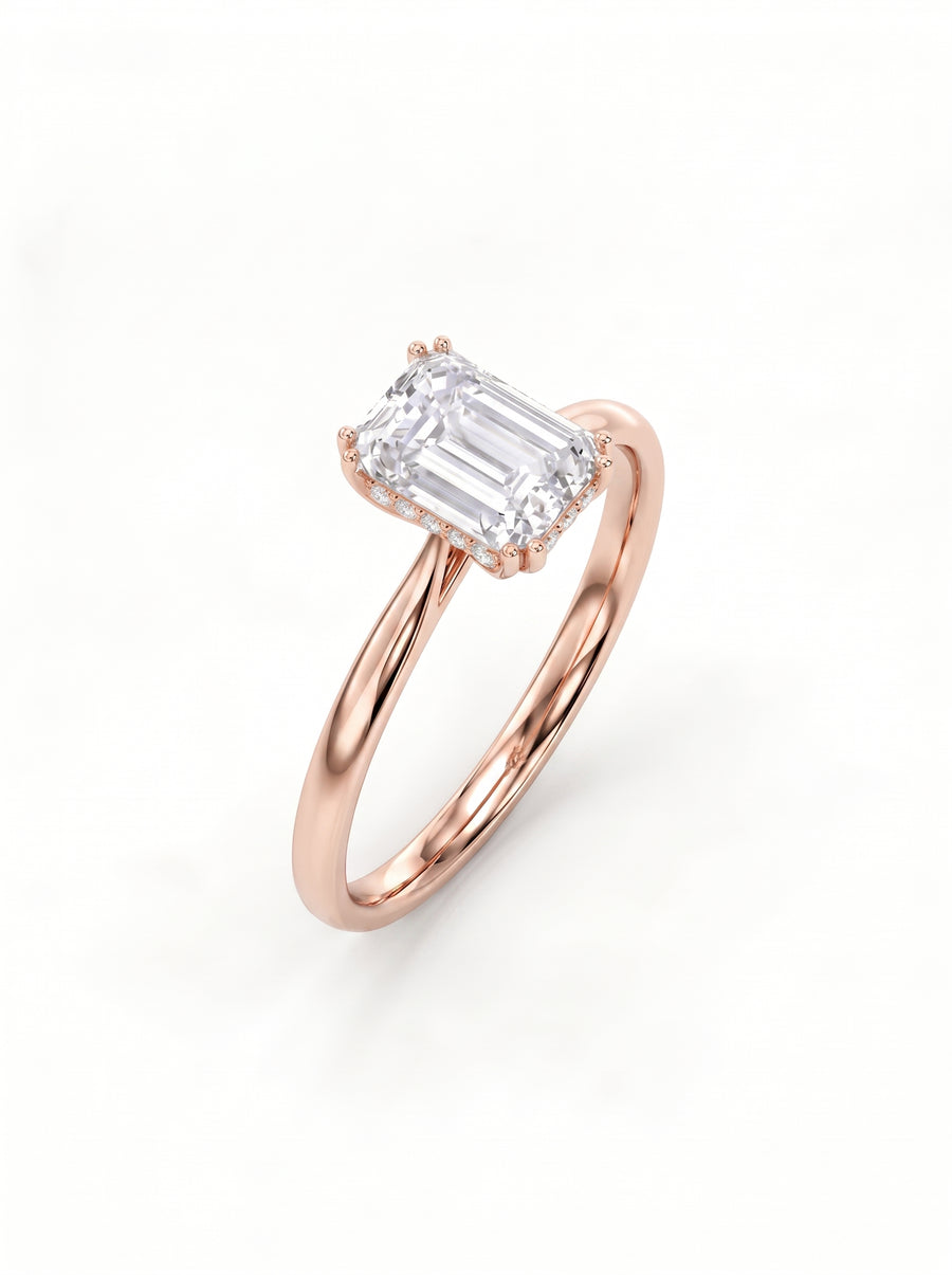 Emerald cut diamond engagement ring with a hidden halo on a polished rose gold band.