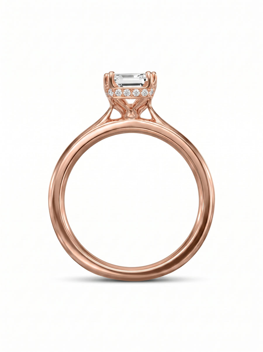Emerald cut diamond engagement ring with a hidden halo on a rose gold band.