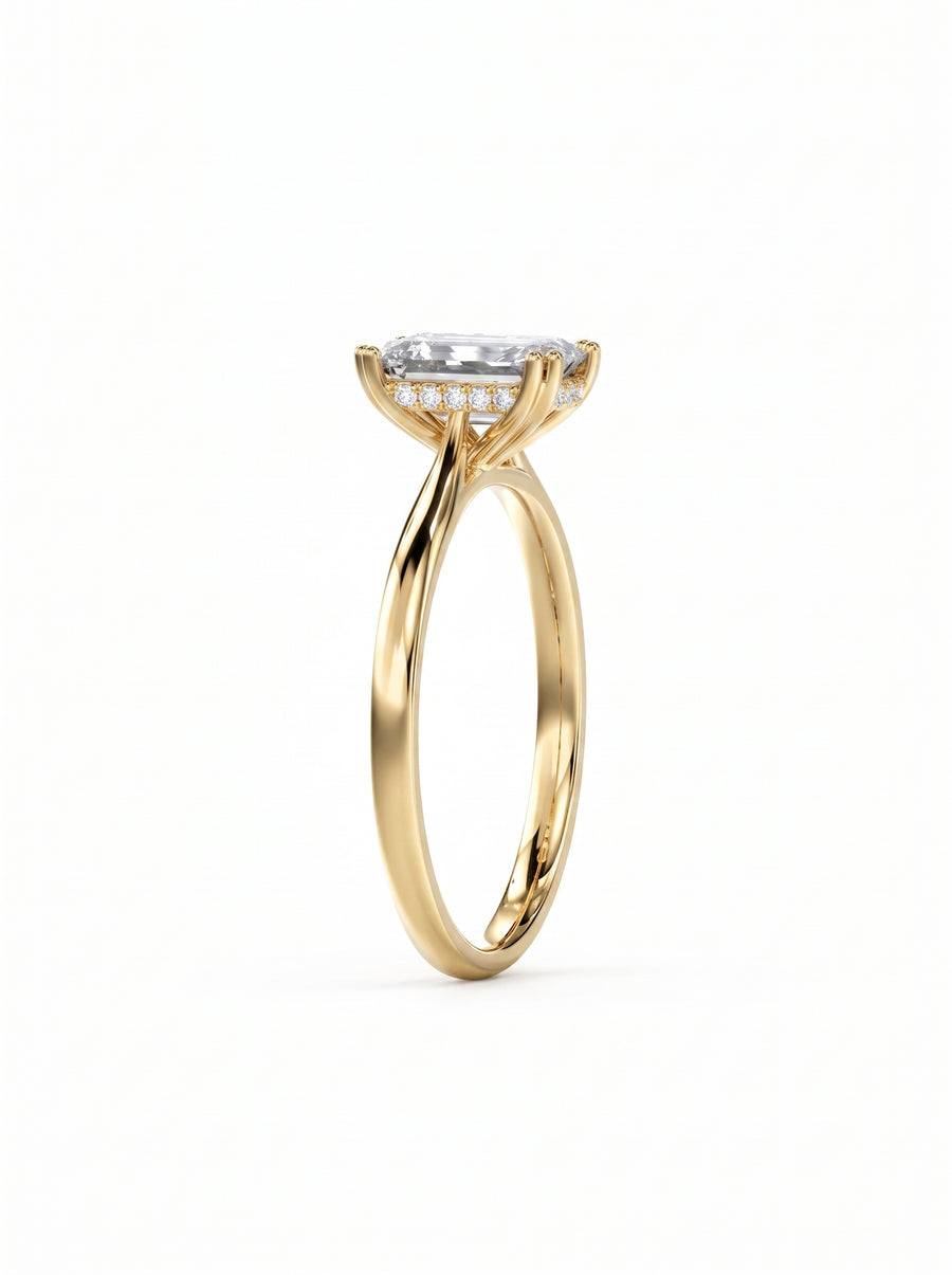 Emerald cut diamond engagement ring with a hidden halo on a polished yellow gold band.
