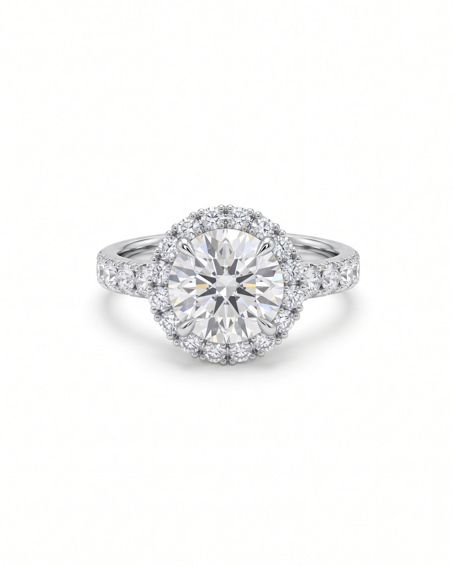 Round diamond cluster engagement ring in white gold with a halo setting and pavé band.
