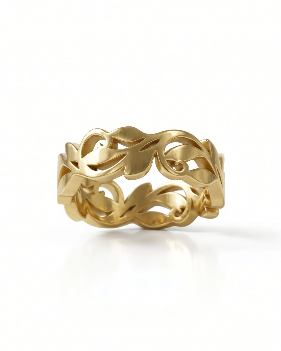 Gold band ring featuring an intricate cutout floral and leaf pattern design.