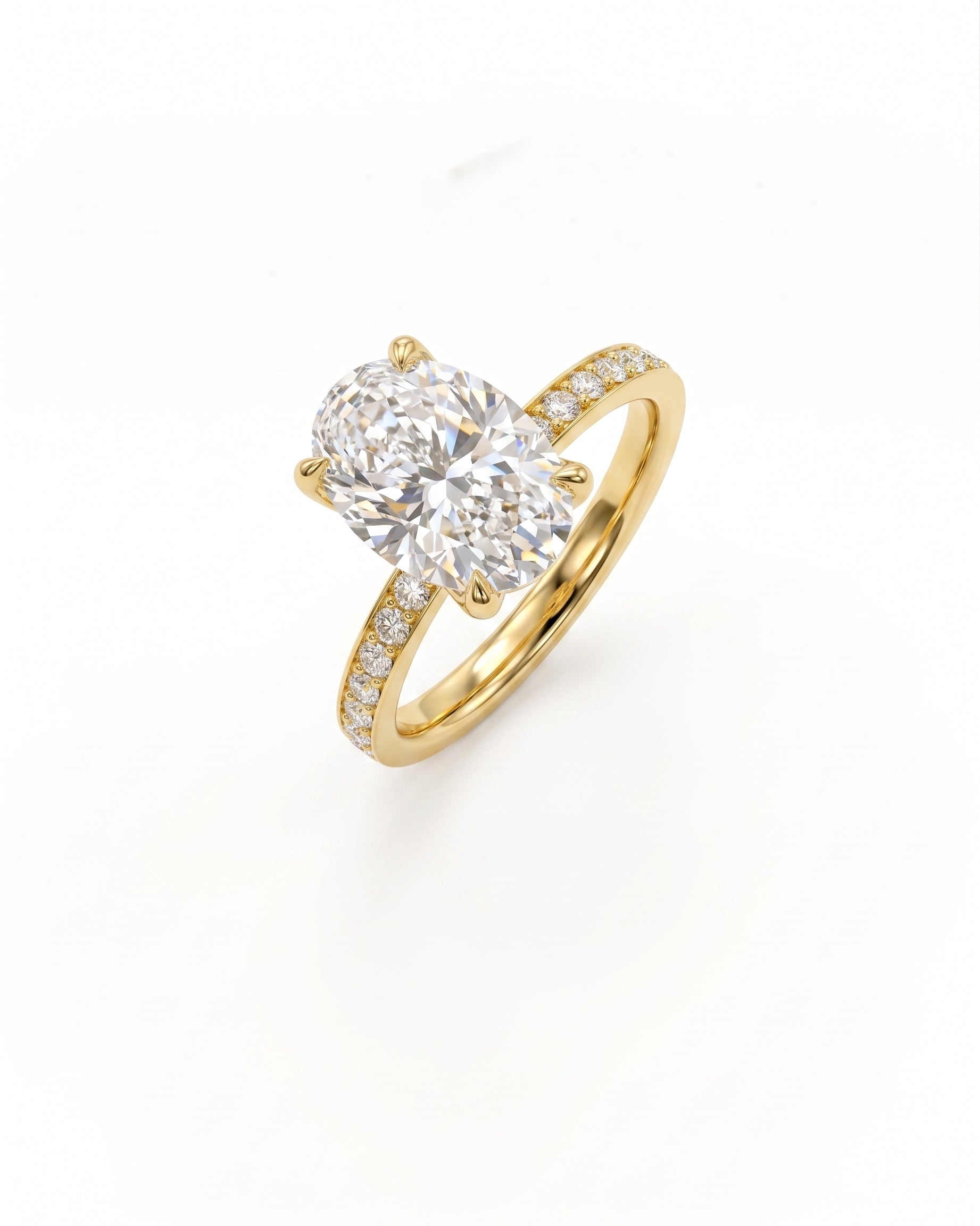 A yellow gold solitaire engagement ring featuring a large oval-cut diamond center stone and a pavé-set diamond band, shown on a clean white background.