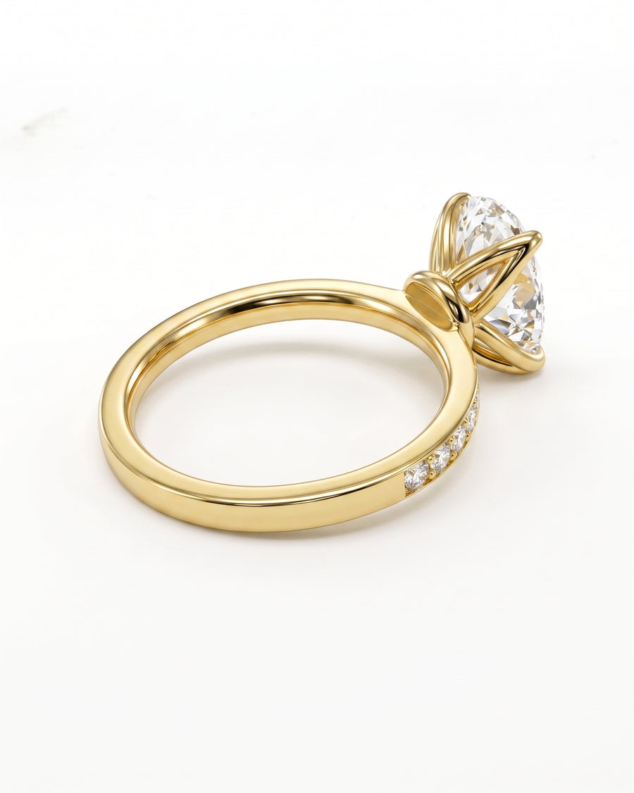 A yellow gold ring with a large marquise-cut clear gemstone in a prong setting and small accent diamonds along the band, shown on a clean white background.