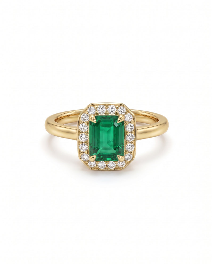 Emerald-cut emerald engagement ring with a diamond halo set in 18ct yellow gold.