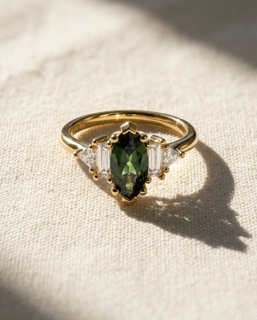 Marquise cut green sapphire engagement ring in 9ct yellow gold with baguette and trillion side stones.
