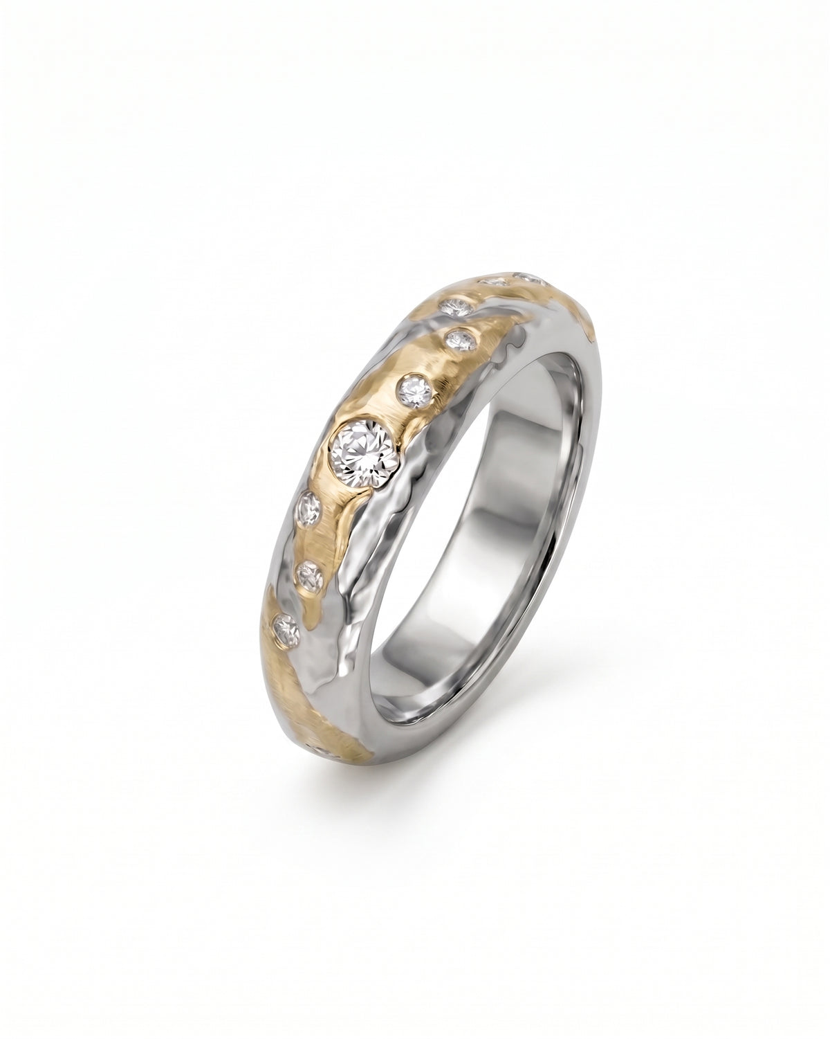 Hammered mixed metal ring in gold and silver with scattered round diamonds on a white background.