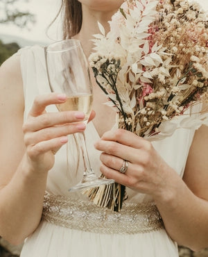 A women holding flowers with her Engagement Ring and wedding ring on