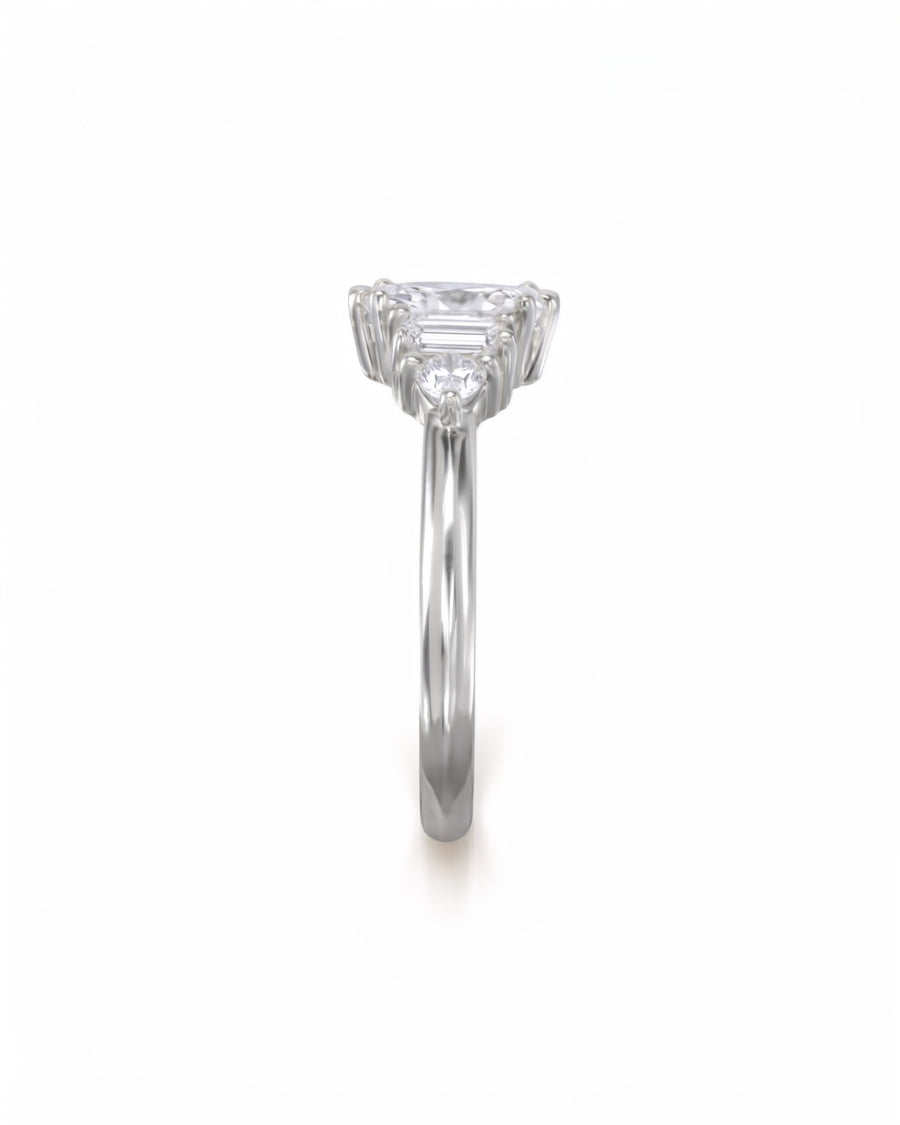 Silver engagement ring with a marquise cut center stone and side baguette diamonds on a polished band.