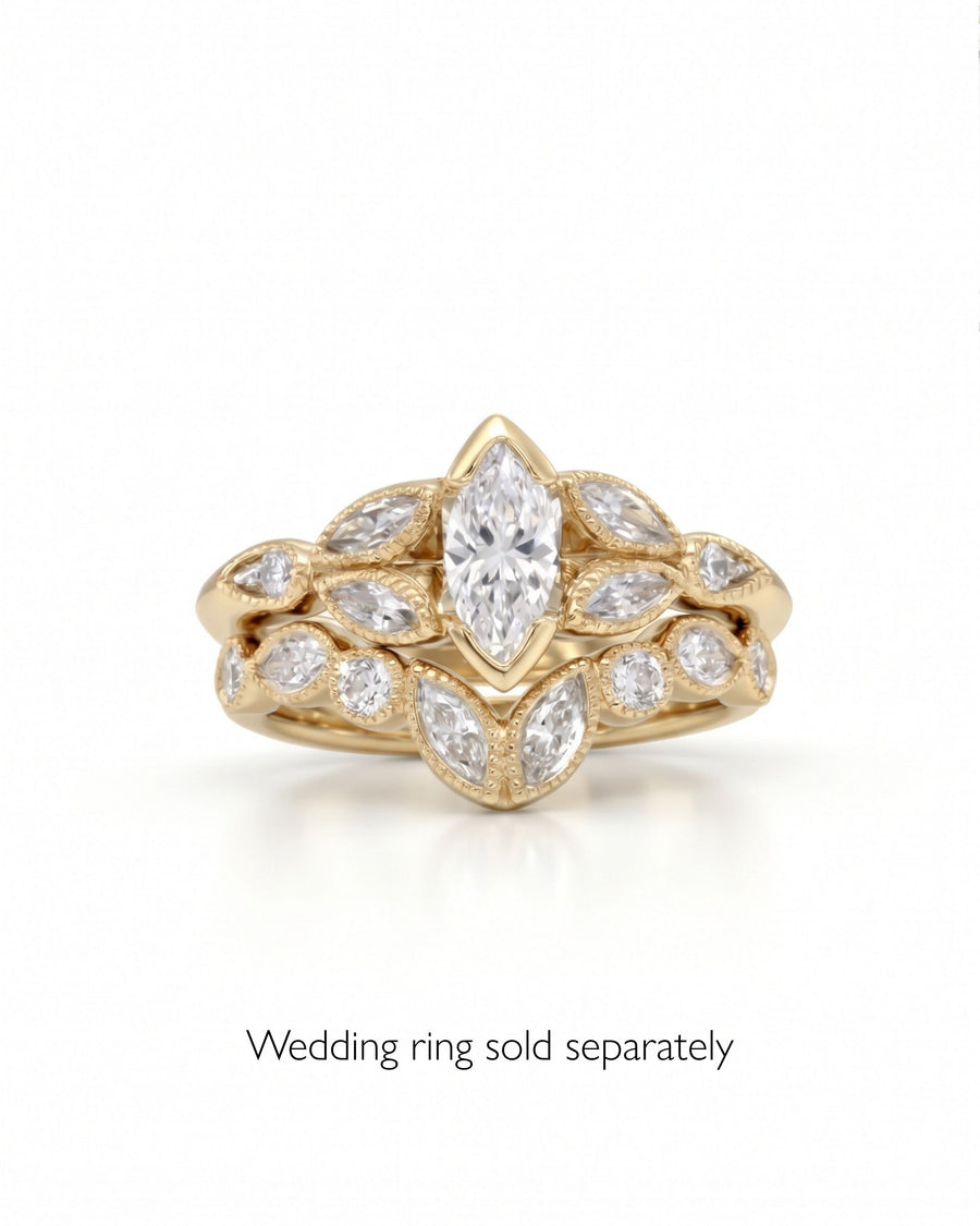 Yellow gold engagement ring featuring a marquise cut center diamond surrounded by smaller marquise and round accent stones.