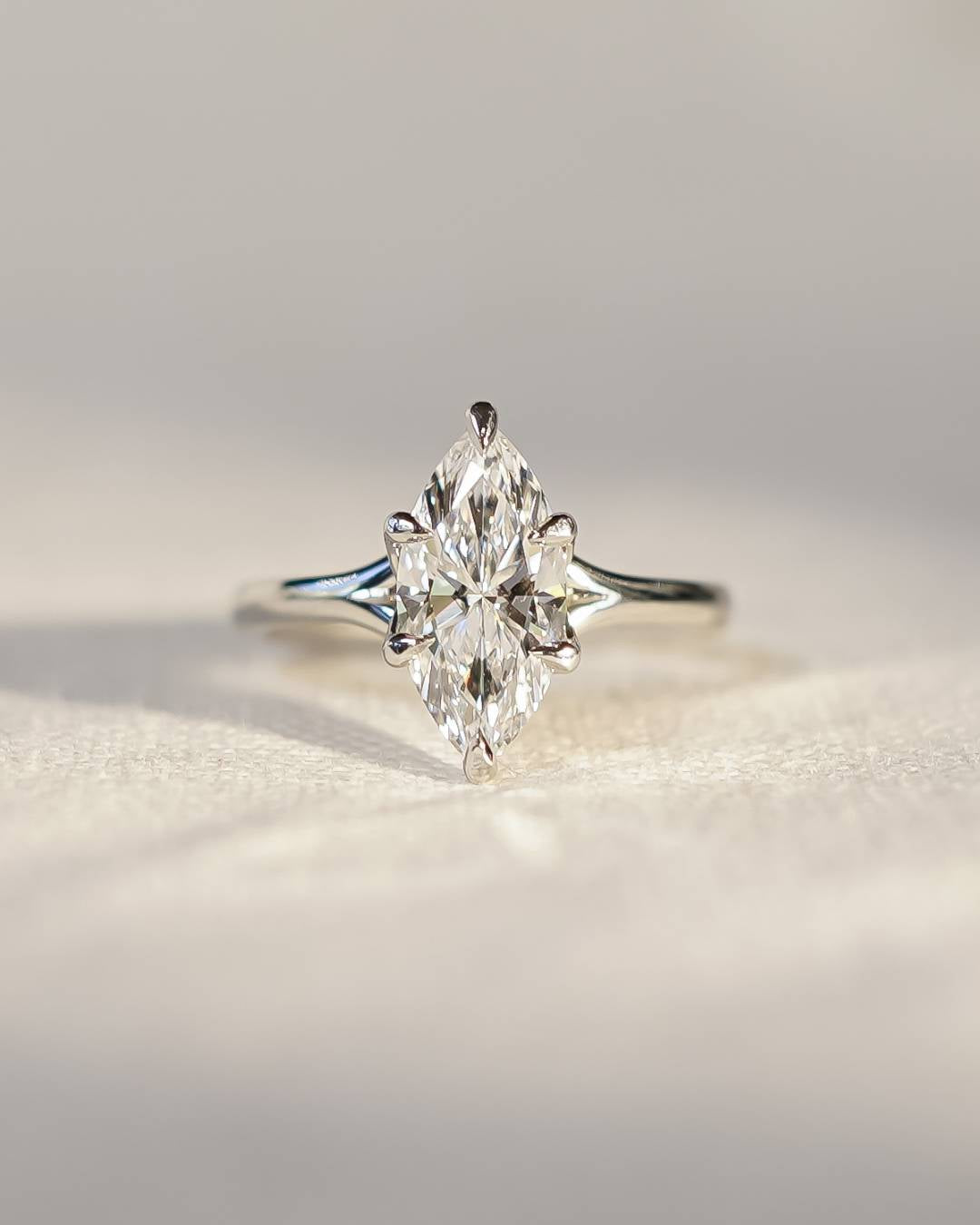 A marquise cut diamond engagement ring set in a slim, polished band with an elegant claw setting.