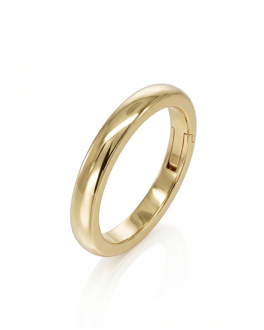 Polished yellow gold men's wedding band featuring a smooth domed surface and a functional side hinge mechanism.