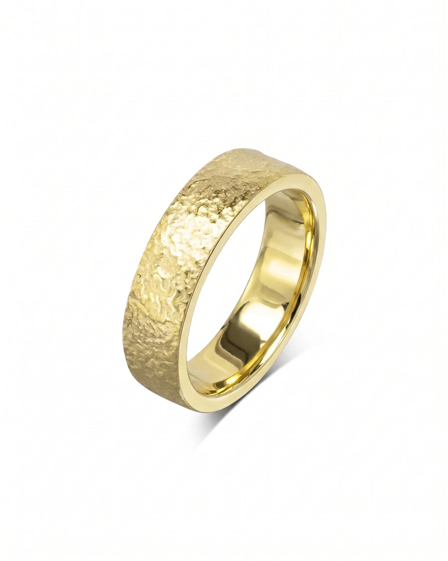 Gold wedding band with a textured, hammered finish and a smooth, polished interior surface.