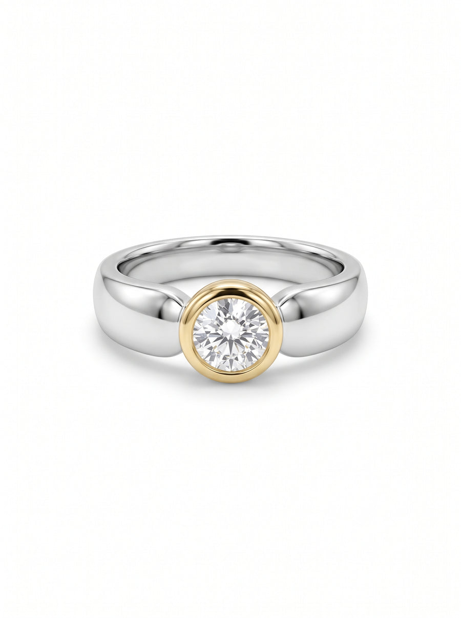 Round diamond ring in a gold bezel setting on a polished silver band.