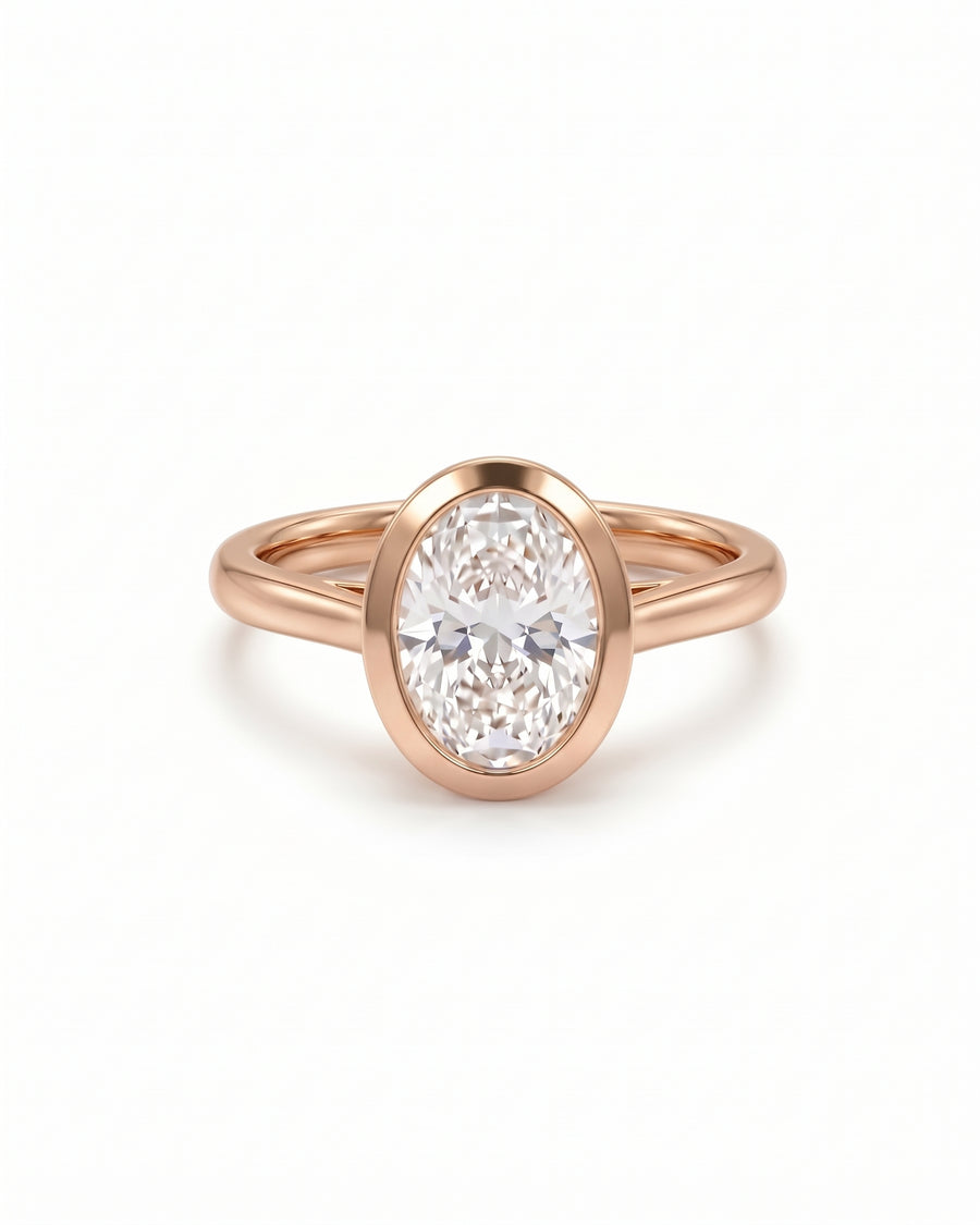 Oval cut diamond engagement ring in a rose gold bezel setting with a cathedral band.