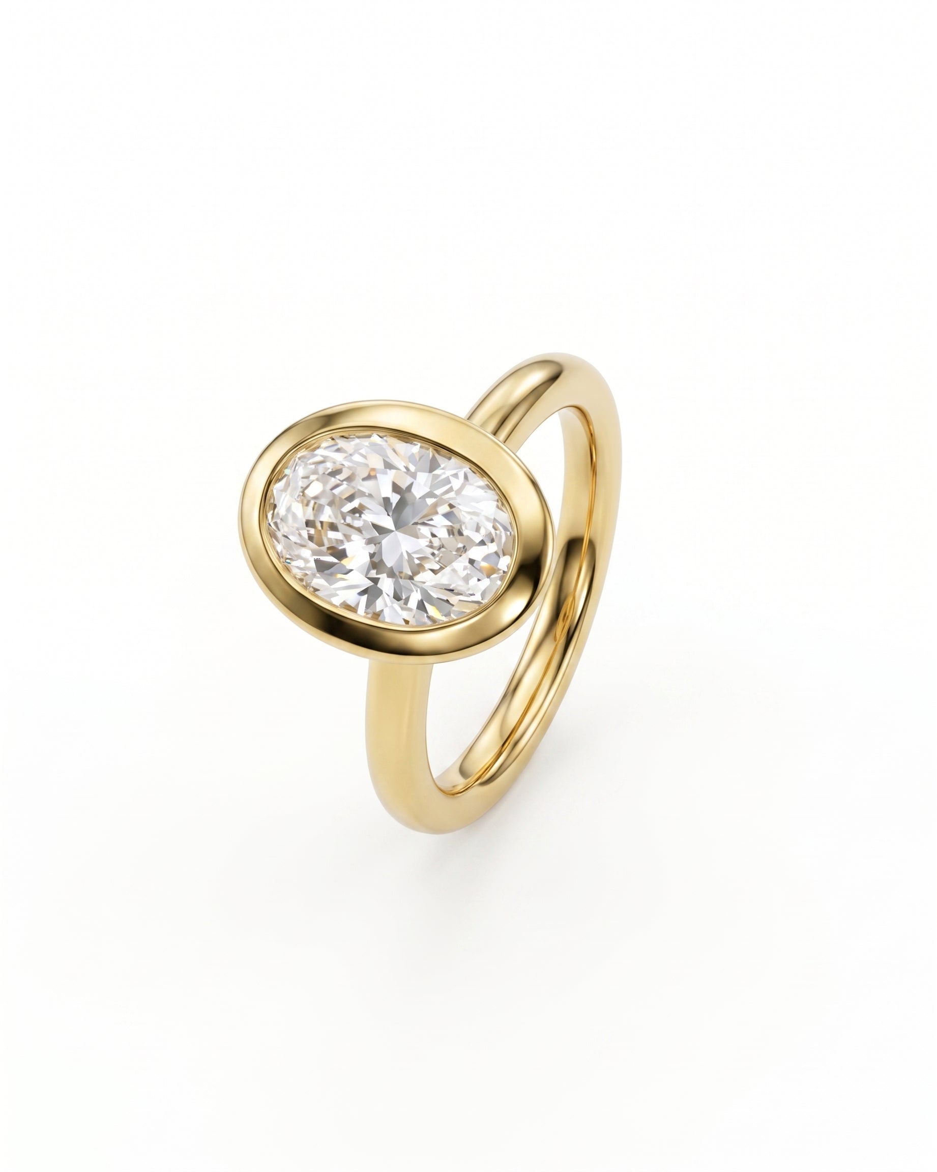 Oval cut diamond engagement ring in a yellow gold bezel setting with a cathedral band.