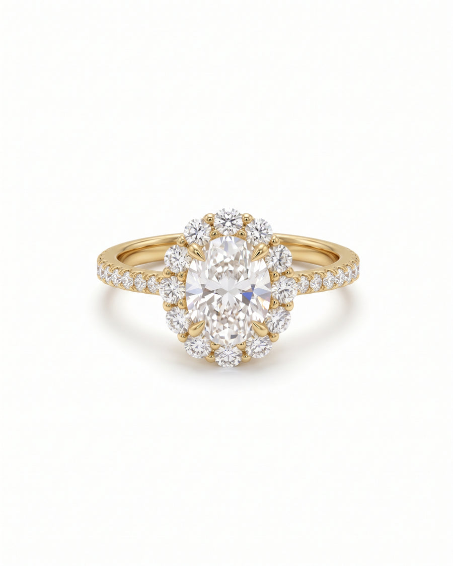Oval cut diamond halo ring in yellow gold with claw settings and a pavé band.