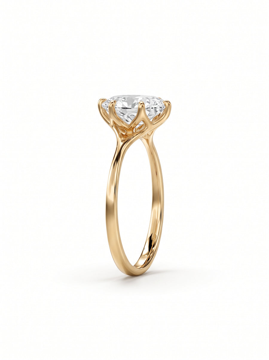 Oval cut diamond engagement ring in 18k yellow gold with a tulip-shaped claw setting.