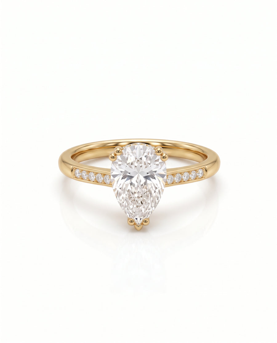 Pear cut diamond engagement ring in yellow gold with a hidden halo and pavé band.
