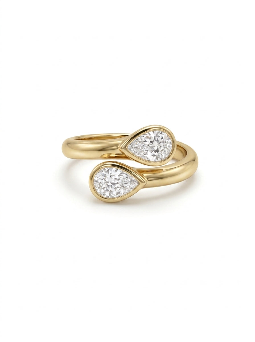 Gold toi et moi ring featuring two pear-cut diamonds in bezel settings on a polished yellow gold band.