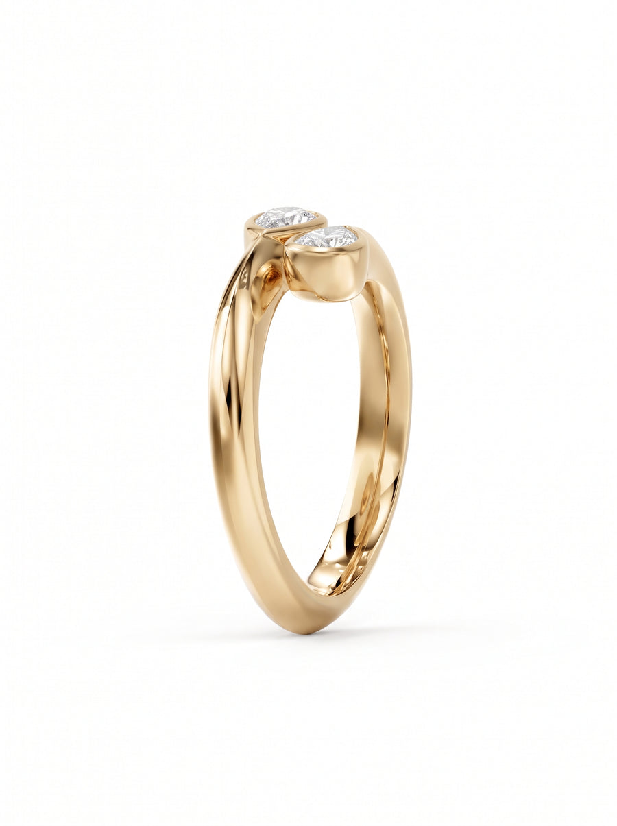 Gold toi et moi engagement ring featuring two pear cut diamonds in a bezel setting.