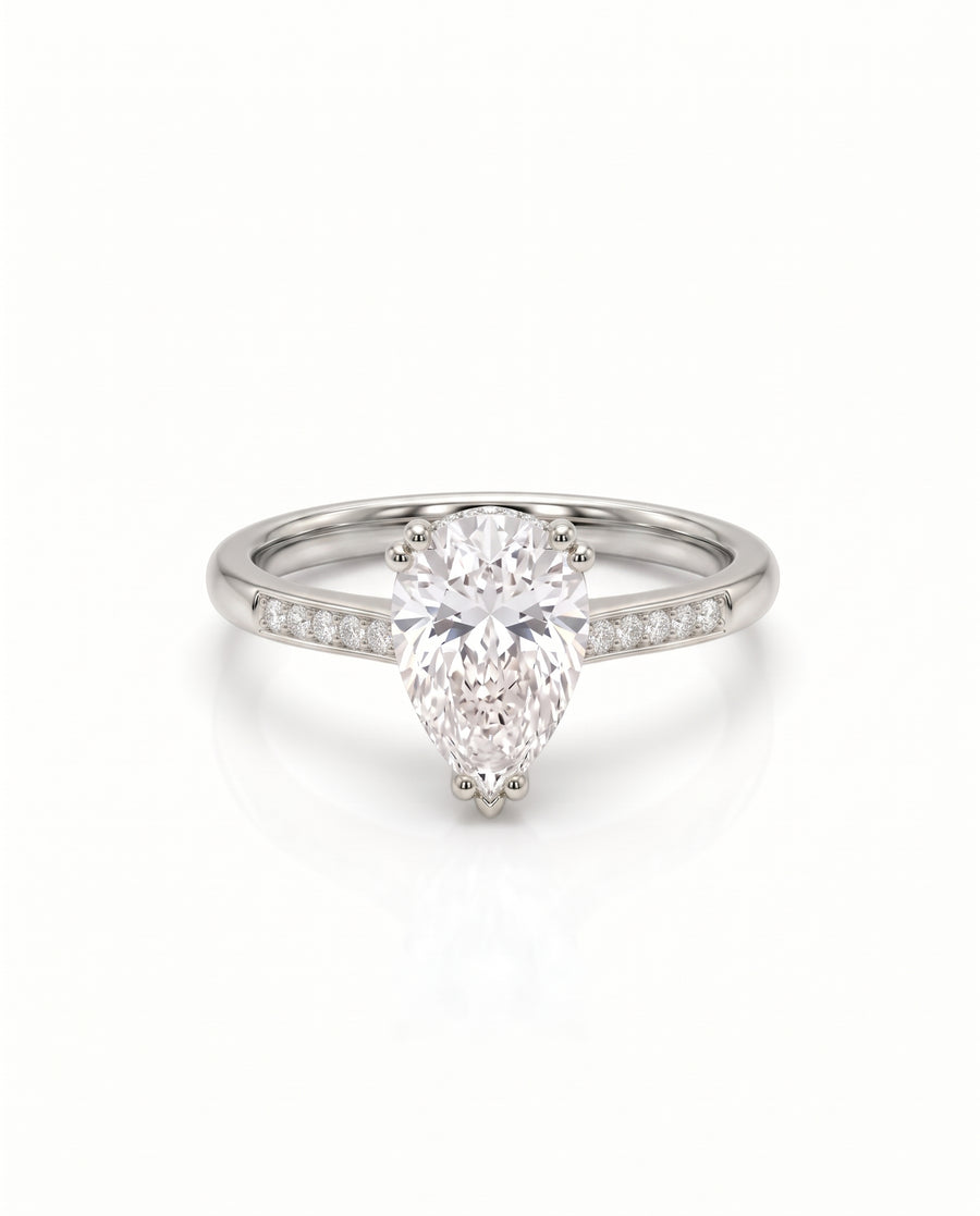 Pear cut diamond engagement ring in platinum with a hidden halo and pavé set band.