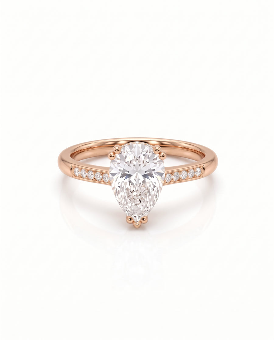 Pear cut diamond engagement ring in rose gold with a hidden halo and pavé band.