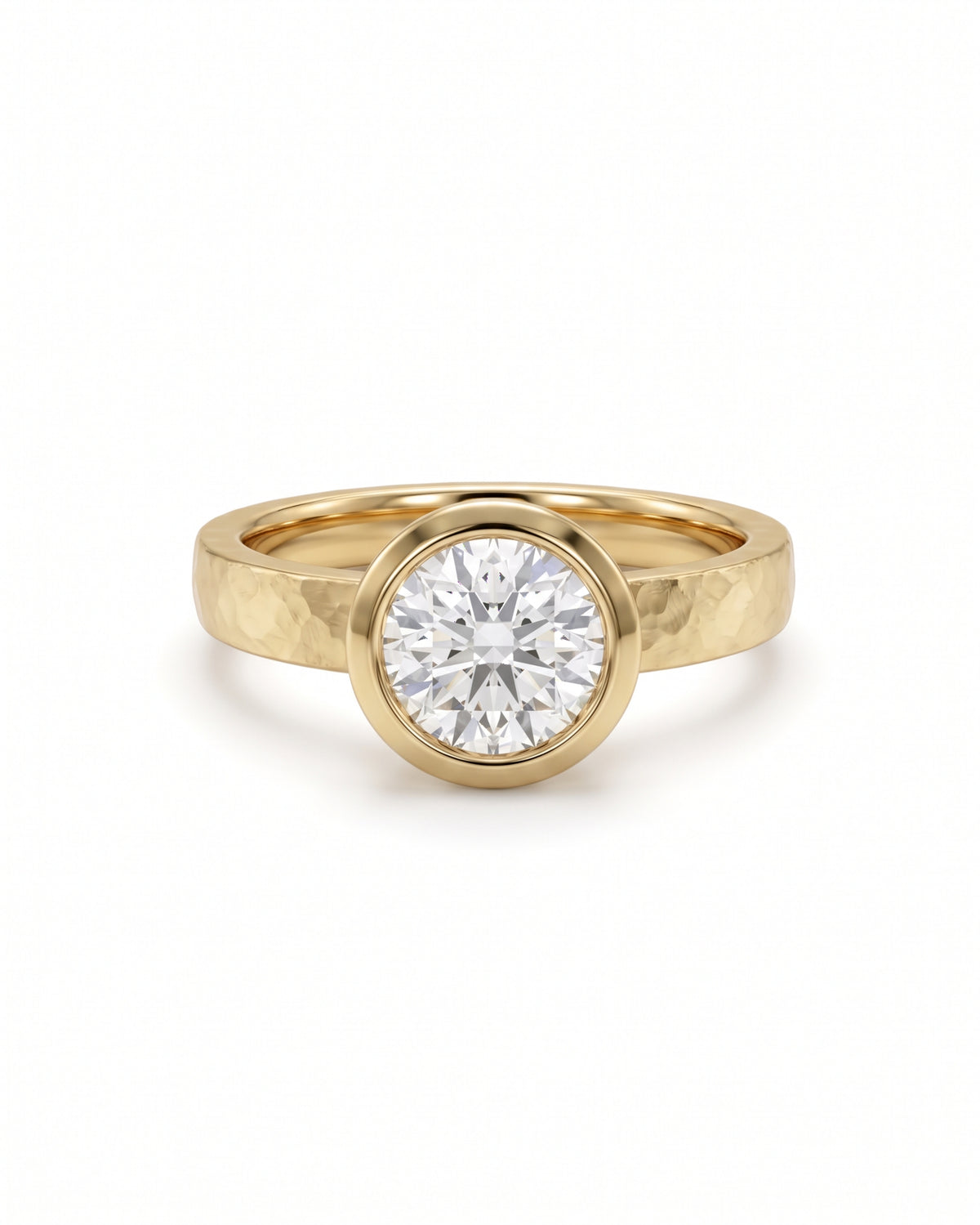Round brilliant cut diamond engagement ring in a yellow gold band with a hammered bezel setting.