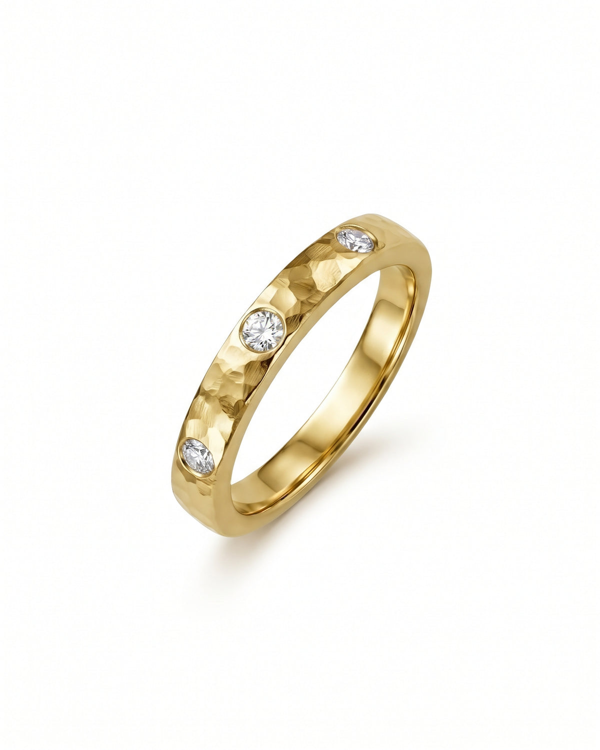 Gold band ring with a hammered texture and three flush-set round diamonds.