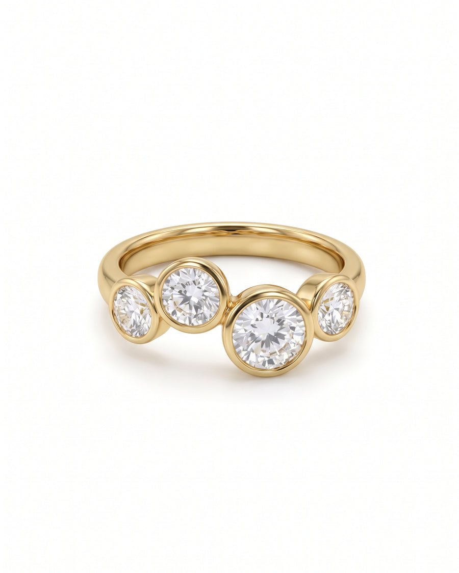Gold ring featuring four bezel-set round diamonds in a staggered bubble design.