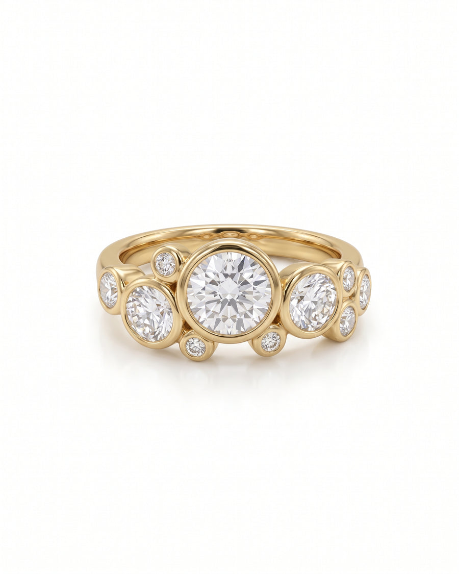 Gold engagement ring featuring multiple round cut diamonds in a bubble-style bezel setting.