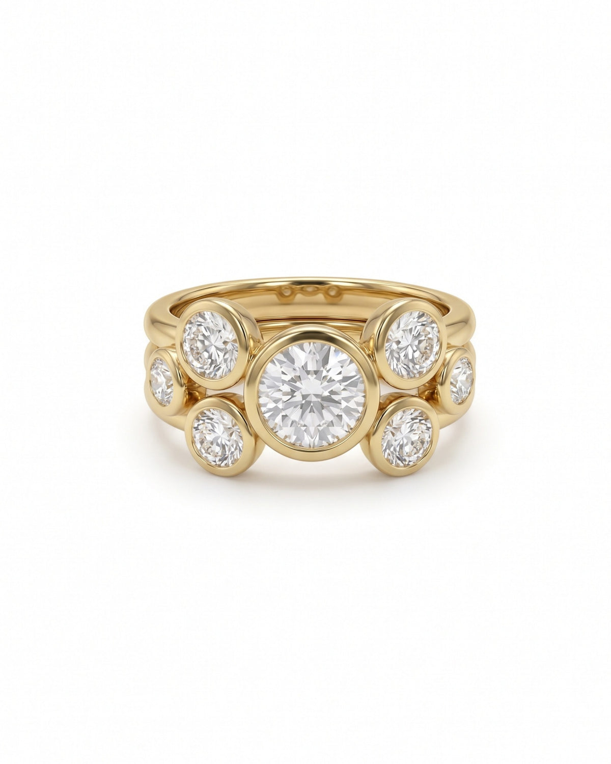 Gold stacking engagement ring featuring a large center round cut diamond surrounded by smaller bezel-set diamonds.