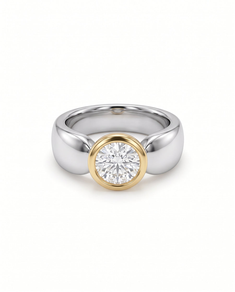 Round diamond solitaire engagement ring with a yellow gold bezel setting on a polished silver band.