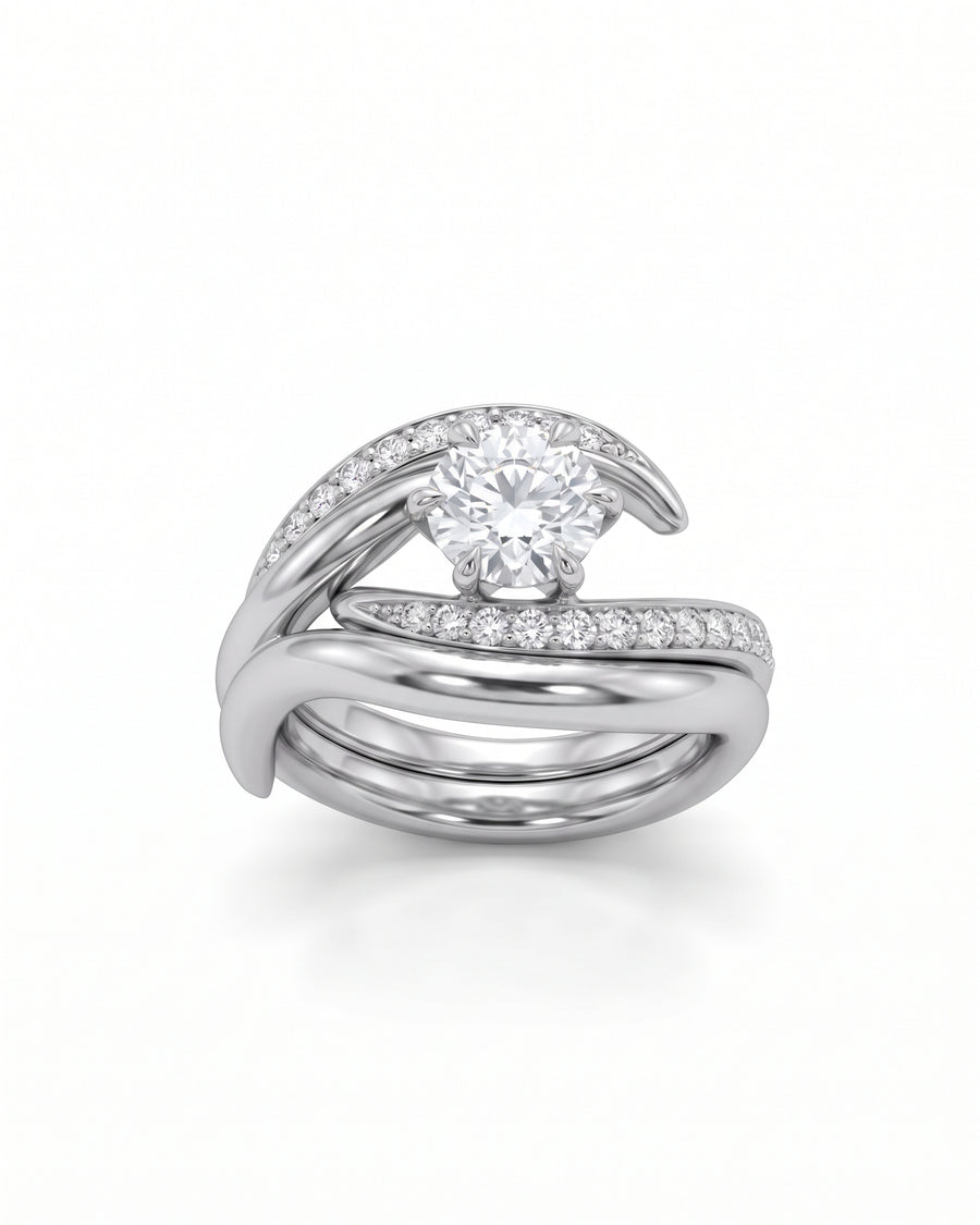 Platinum engagement and wedding ring set with a round center diamond and pavé-set side stones in a curved design.