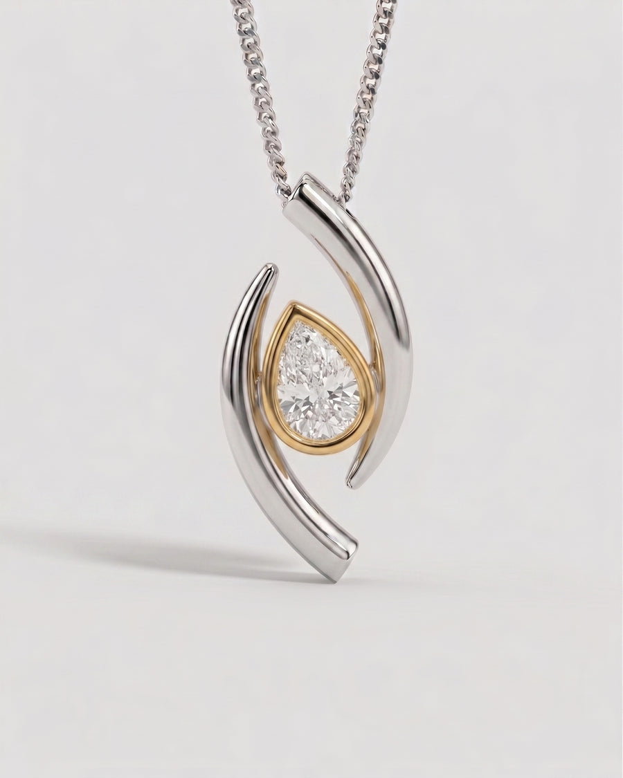 Pear-shaped diamond pendant in a two-tone gold and silver curved setting on a matching chain.