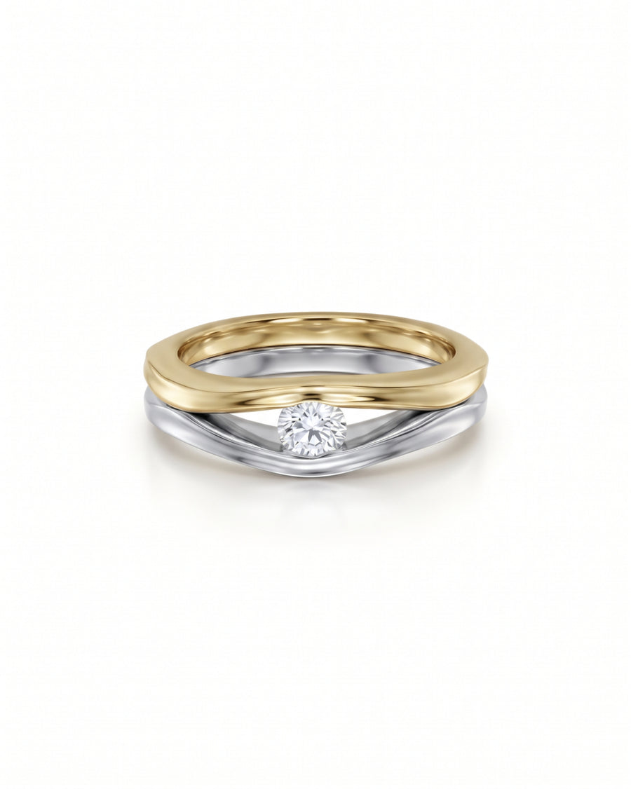 Two-tone gold and silver solitaire engagement ring featuring a round brilliant-cut diamond in a curved band design.