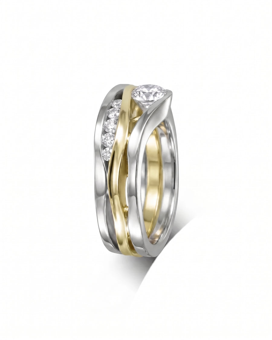 Three-band ring in white and yellow gold featuring a center diamond and channel-set accent stones.