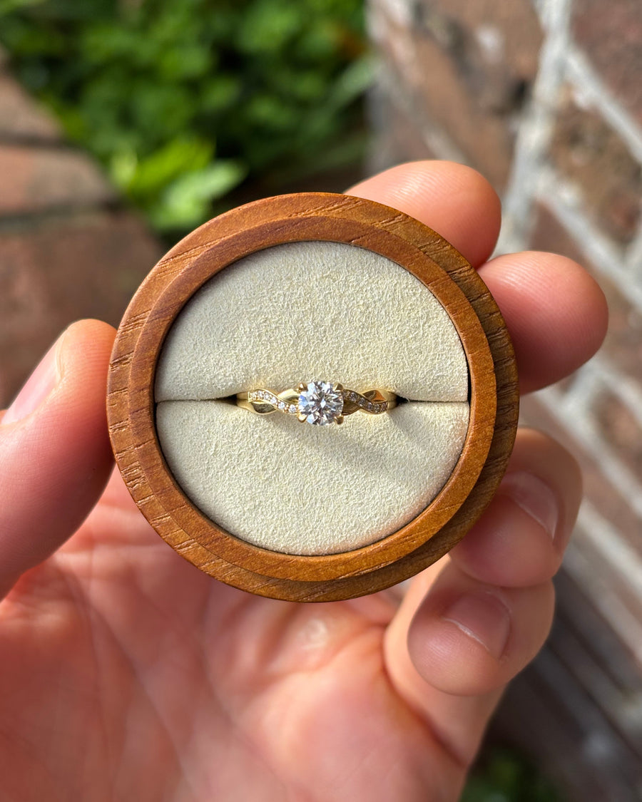 0.53ct round cut diamond engagement ring in 18ct yellow gold with a twist claw setting in a wooden box.