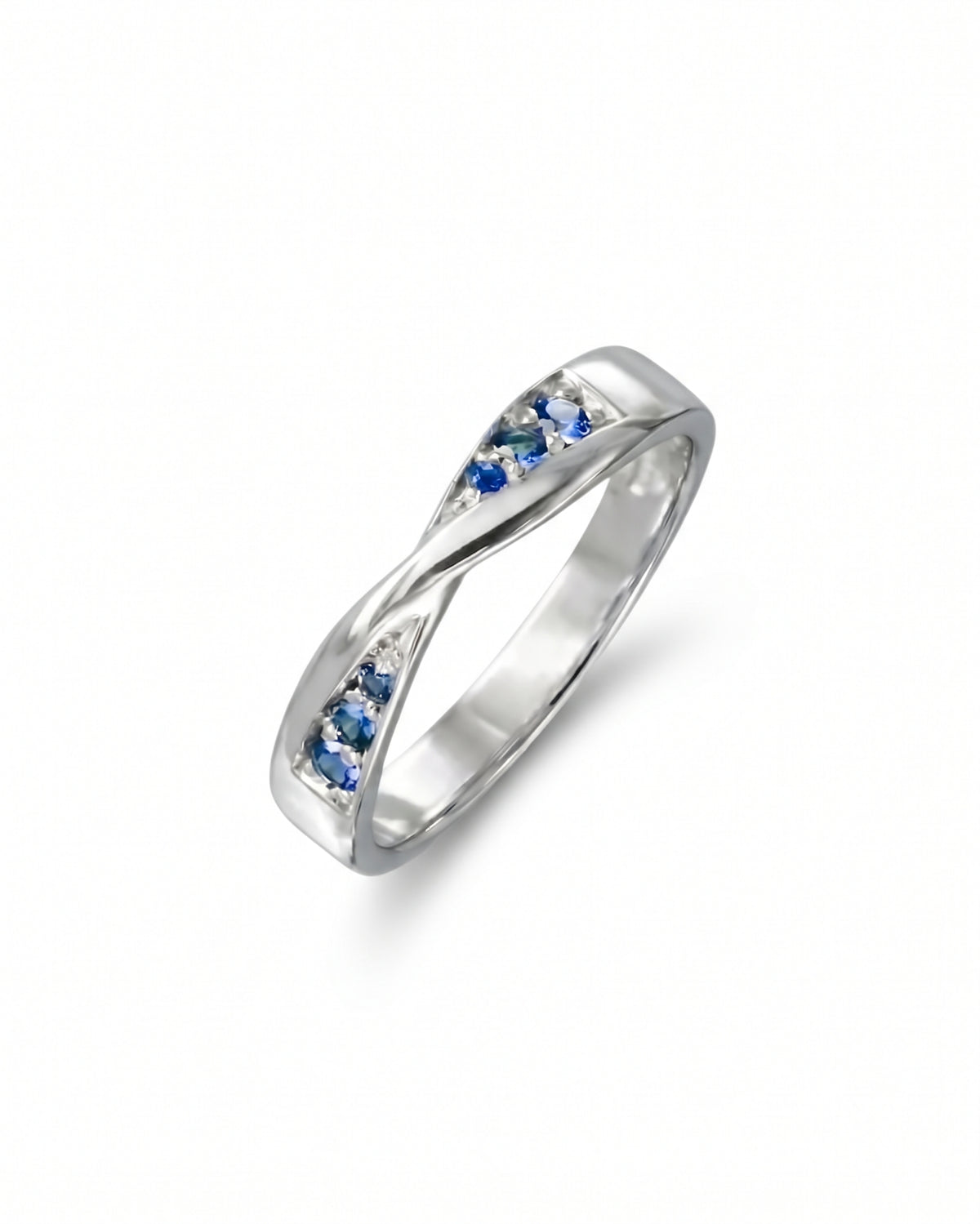 Silver twist ring featuring small blue sapphire gemstones set into the band.