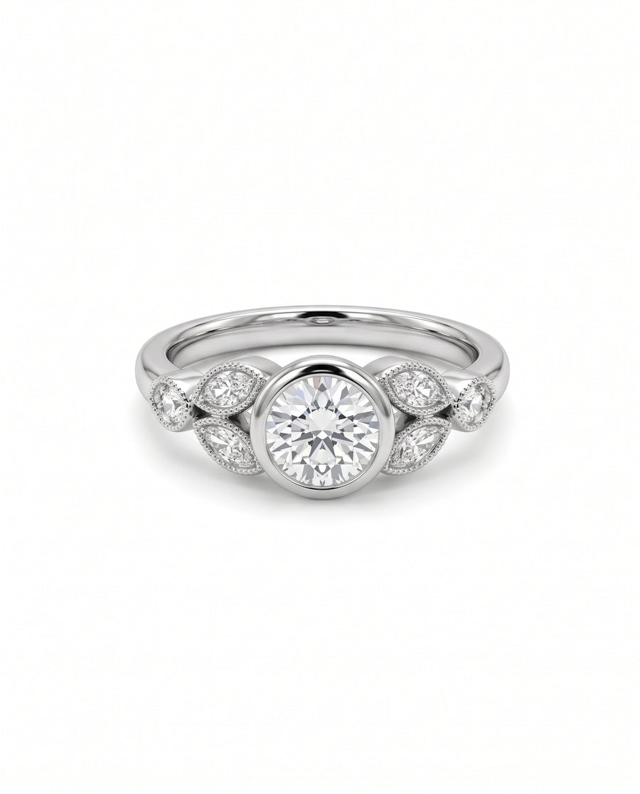 Vintage platinum engagement ring with a round bezel-set center diamond and marquise side stones.