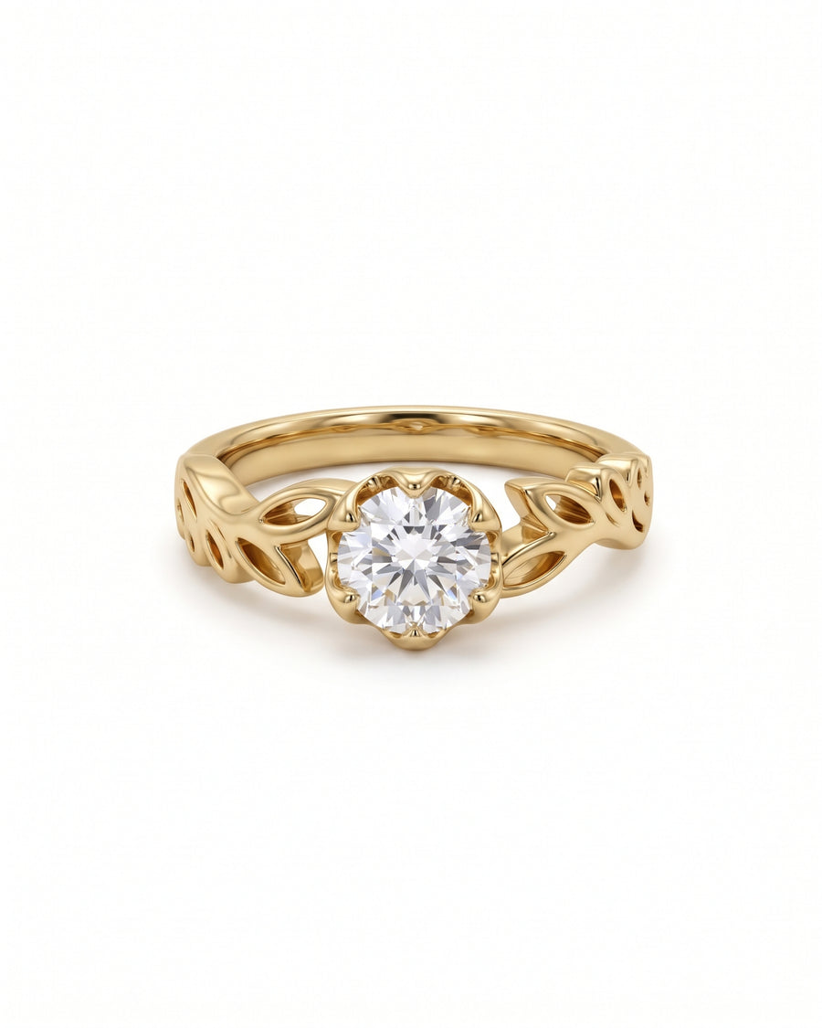 Round diamond engagement ring in yellow gold with a leaf-inspired band design.