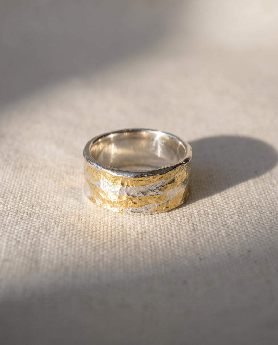 Wide band ring featuring a hammered texture in mixed silver and 18ct yellow gold.